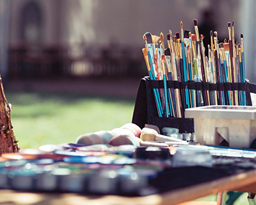 Paint brushes and art supplies on a table   