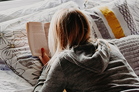 a person is reading a book in bed